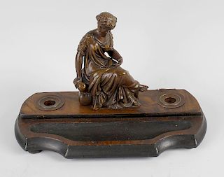 A carved wooden inkstand, having classical female figure seated upon the shaped base flanked by dual
