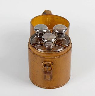 An unusual early 20th century hinged leather travelling drinks case of cylindrical form, fitted with