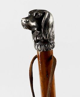 An early 20th century stained wooden walking cane, the cast metal handle modelled as the head of a s