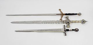 Four Marto Toledo replica swords, to include large cast metal example, the handle detailed with face