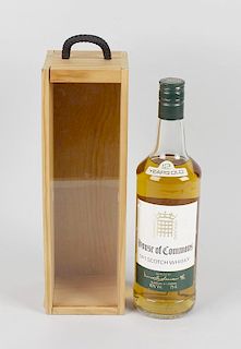 A cased bottle of House of Commons Scotch Whisky. The wooden case with sliding glazed front beneath