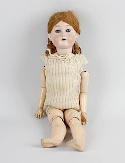 An A W German bisque headed doll, modelled as a young girl with opening blue glass eyes and partly o