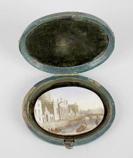 A ceramic oval miniature, depicting a river view of the Four Courts in Dublin, in oval, green, snake