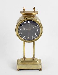 A brass gravity clock. Early 20th century, the 3.25-inch plastic dial with Arabic chapters and dotte