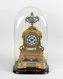 A 19th century gilt spelter cased clock, the arched shaped case with applied porcelain urn finial, a