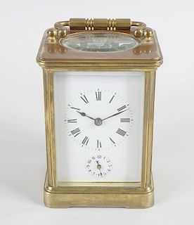 A brass cased carriage clock. The white enamel Roman dial above subsidiary Arabic alarm dial, the tw