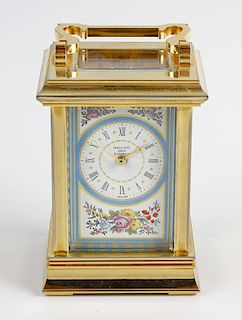 A Halcyon Days enamel carriage clock. The white enamelled Roman dial decorated with floral spandrels