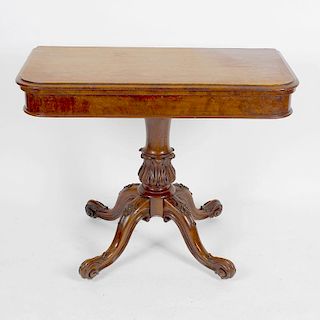 A Victorian walnut fold-over pedestal card table.The moulded oblong top enclosing a circular playing