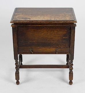A 1930's oak sewing table, the hinged rectangular top with moulded edge lifting to reveal a plain in