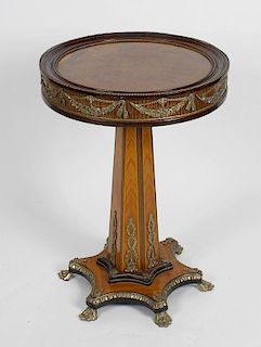 A French style brass mounted walnut and kingwood pedestal table, the circular walnut top with moulde