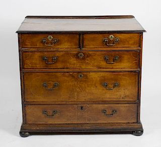 A walnut chest of drawers. The rectangular top having banded inlay above two short over three long g