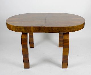An Art Deco walnut extending dinner table. The oval top with concealed additional leaf, raised upon