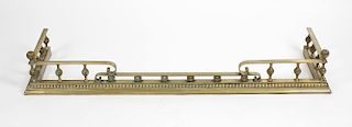 A brass fender, having scrolled and stepped rail above the knopped gallery and with a beaded rim to