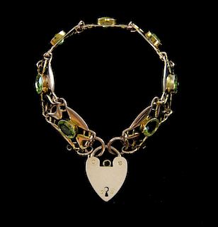 Gold and peridot bracelet, composed of openwork plaques in the Arts and Crafts manner, padlock marke