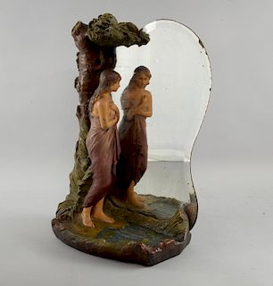 A Continental figural mirror group, circa 1900, depicting a young girl draped in a robe looking at h