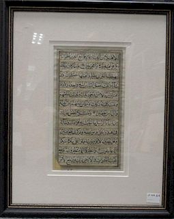 A manuscript leaf with twelve lines of Arabic script within a gilt border, on vellum (one lower corn