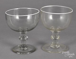 Two colorless glass footed bowls, 19th c., each with a white enameled rim
