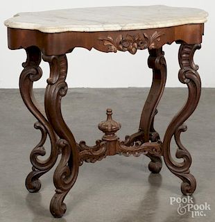Victorian walnut marble top stand, 19th c., with a shaped top, a carved apron, and carved legs