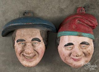 Two painted cast iron wall masks, ca. 1900, 12 1/4'' h. and 13 1/4'' h.