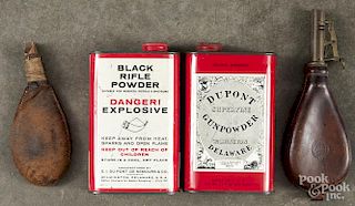 Two leather powder flasks, 19th c., together with two Dupont powder tins, mid 20th c.