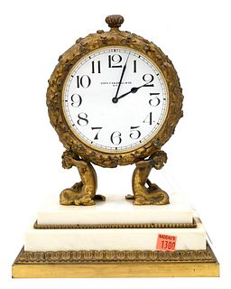 Edward F Caldwell Figural Bronze Mantle Clock, having round clock face resting on Triton over rectangle marble base, height 12 inches.