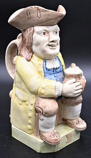 Pearlware Toby Jug, to include Ralph Wood, depicting a seated figure holding a beer, height 9 3/4 inches.