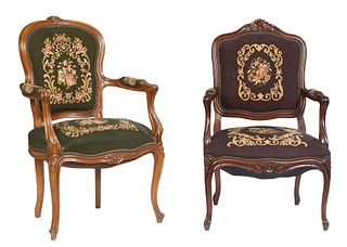 Near Pair of Louis XV Style Carved Walnut Fauteuils, early 20th c., with floral carved canted cushioned backs to curved arms and bowed cushioned seats