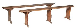 Near Pair of French Provincial Carved Pine Benches, early 20th c., the rounded plank top on trestle form supports, larger- H.- 20 W.- 79 1/2 in., D.- 