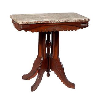 American Carved Walnut Marble Top Lamp Table, c. 1890, the canted corner highly figured brown marble over a scalloped skirt, on four reeded splayed le