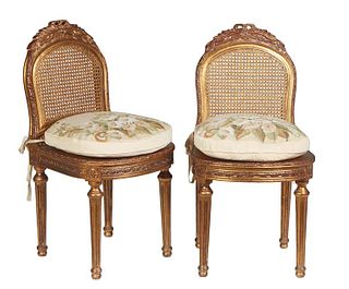 Pair of French Louis XVI Style Carved Giltwood Side Chairs, 19th c., the arched caned back with a leaf carved crest, over a bowed cane seat with a wid