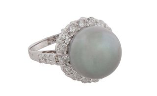 Lady's 14K White Gold Dinner Ring, with a 12mm black Tahitian cultured pearl, atop a border of round diamonds, the shoulders of the band also mounted 
