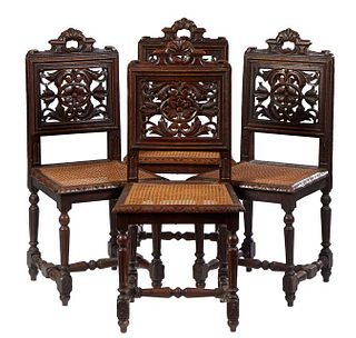 Set of Four French Carved Oak Henri II Style Side Chairs, c. 1880, the canted back with an arched hand hole crest over a horizontal pierced leaf and f