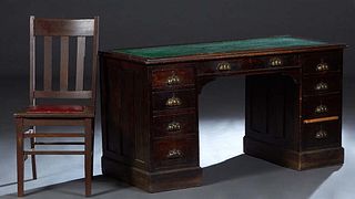 English Carved Oak Desk, c. 1910, the stepped ogee edge top with a green faux leather inset writing surface, over a center frieze drawer, flanked by d