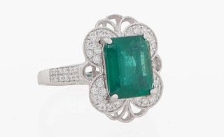 Lady's Platinum Dinner Ring , with a 3.39 ct. rectangular emerald, atop a pierced border with four demilune diamond mounted corners, the shoulders of 