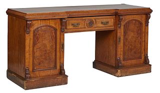American Carved Walnut Sideboard, late 19th c., the slanted edge breakfront top over a wide center frieze drawer, flanked by arched cupboard doors, th