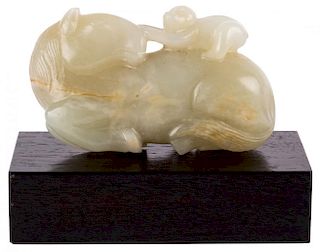 A PALE CELADON JADE OF A RECUMBENT HORSE WITH MONKEY GROUP, QING DYNASTY, 18TH CENTURY