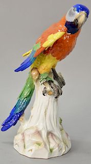 Large Meissen porcelain parrot having bright plumage perched on a large tree stump having blue crossed swords mark "A43A" (one wing ...