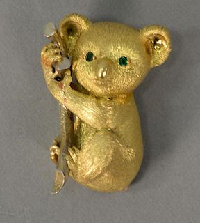 18K gold koala bear brooch holding a telephone with emerald eyes. 
22.4 grams