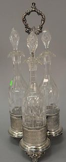 Tantalus having three crystal bottles with silverplated caddy. 
ht. 15 in.