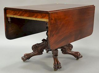 Federal mahogany drop leaf table with carved pedestal base on four carved paw foot legs, ends with black and gold stenciling, circa ...