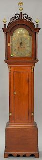 Mahogany tall case clock with fretwork top, brass dial, and fluted case with gilt capitals all set on base with bracket feet and bra...
