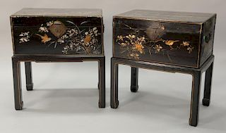 Pair of black lacquered Asian lift top chest on custom stands having courtyard scene painted on top. 
ht. 31 in.; top: 18 1/4" x 27 ...