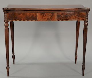 Sheraton mahogany game table with shaped top over conforming frieze set on turned and fluted legs. ht. 29 3/4 in.; wd. 34 3/4 in.; ...