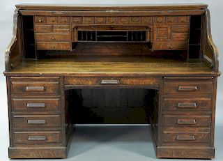 Derby oak S roll top desk with 28 drawers and pull out interior having high S roll and raised panels. 
ht. 51 in.; wd. 72 in.; dp. 3...