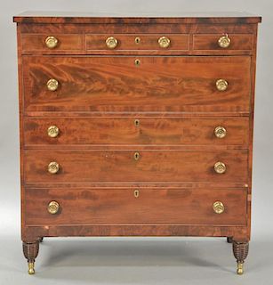 Sheraton mahogany chest with three short drawers over four long drawers all set on turned legs ending in brass capped feet. 
ht. 52 ...