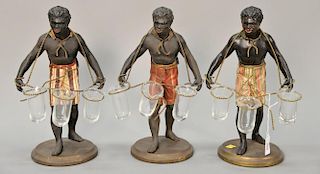 Petites choses, three Black Americana figural men carrying three glass bud vases, marked Petites Choses on base. 
ht. 13 1/2 in.