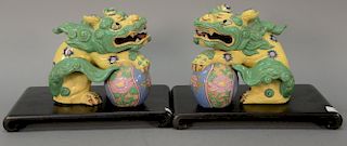 Pair of porcelain foo dogs on balls set on rectangular wood stands. 
lg. 8 1/2 in.; dia of shade 15 1/2 in.; ht. 7 1/2 in.; total ht...