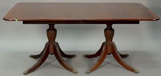Custom mahogany double pedestal dining table with banded inlaid top on carved pedestals, each set on four downswept members ending i...