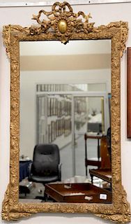Large French gilt mirror, carved wood with gesso frame of scrolling leaf and flower. 
53" x 32"