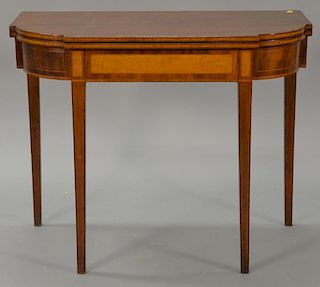 Federal mahogany game table having D shaped top over conforming frieze with figured maple panel, all set on inlaid square tapered le...